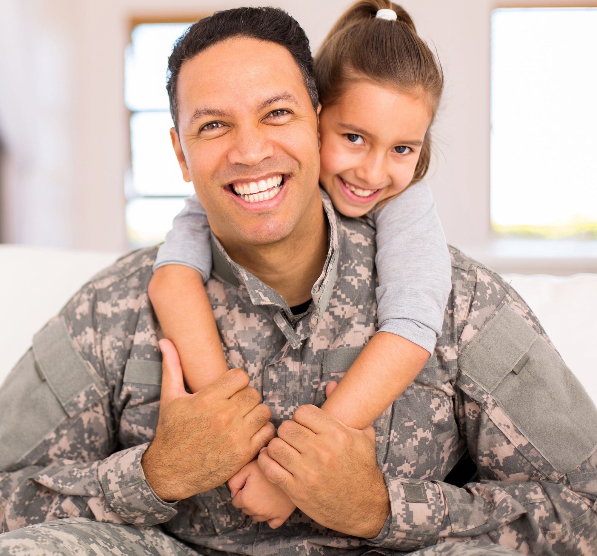 A daughter hugs her smiling US Army Dad.