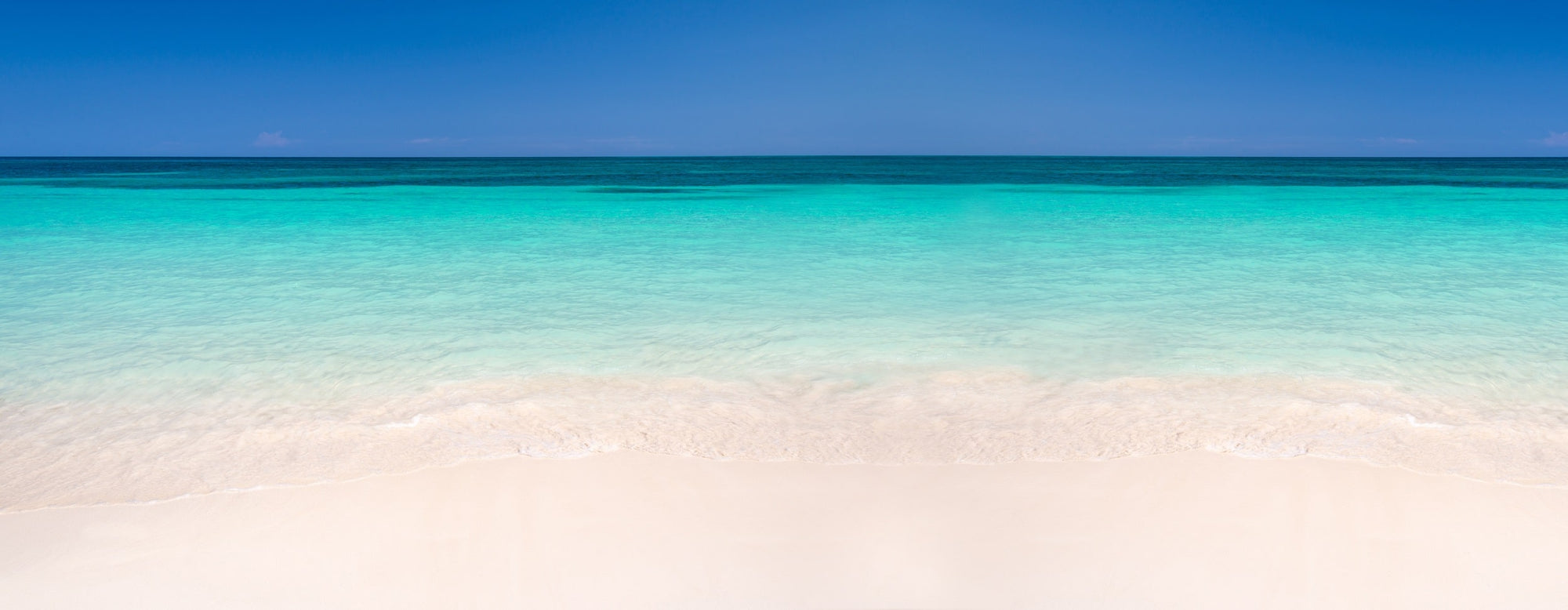 Pristine blue-green water and perfect white sand on a Caribbean beach serve as a perfect example of why we need to protect our planet and keep our oceans clean.