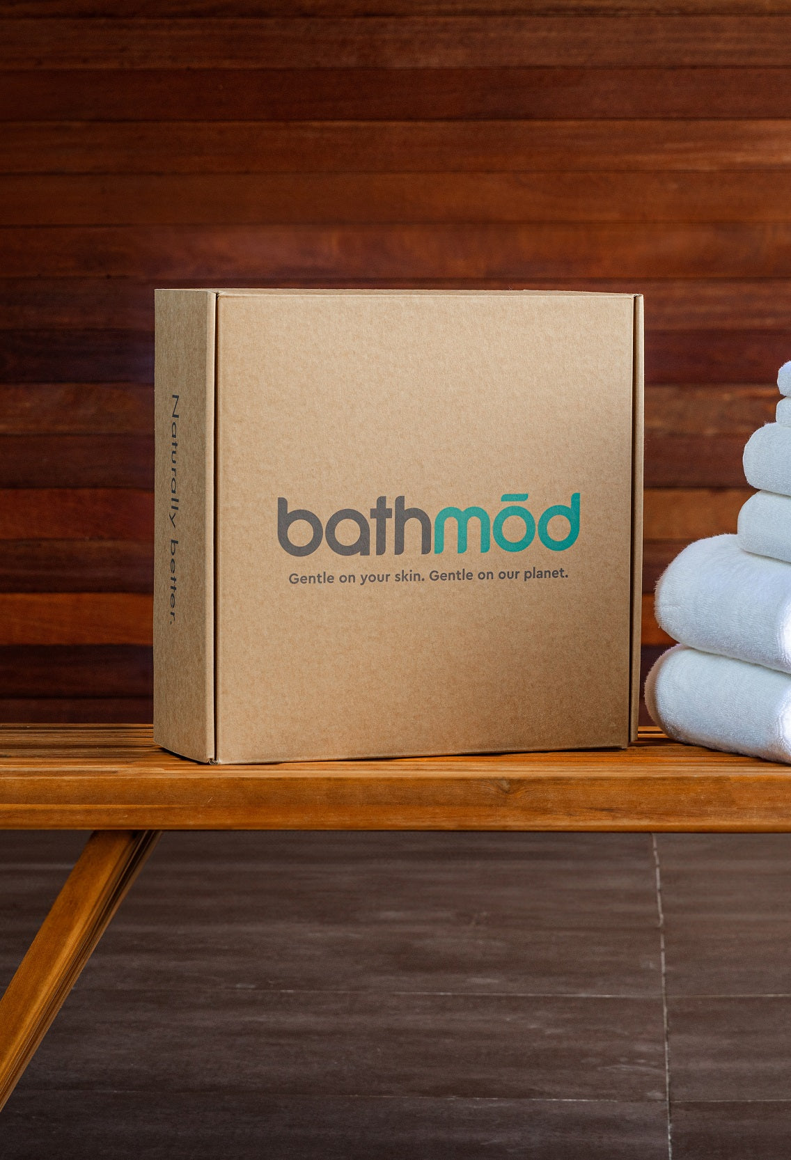 A sustainable towel brand's packaging sits next to a stack of its organic towels.