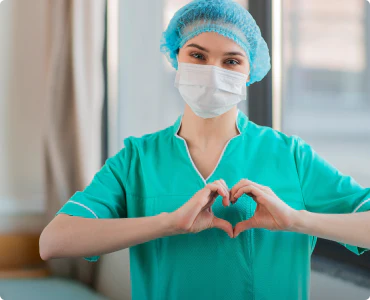 A health care worker is making a heart shape with her hands, showing the need for businesses to provide discounts to first responders and health care workers.